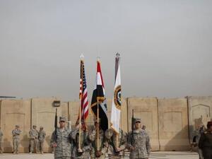 حمل العلم العراقي والاميركي وعلم والقوات الاميركية خلال مراسم انسحاب القوات الاميركية من العراق
