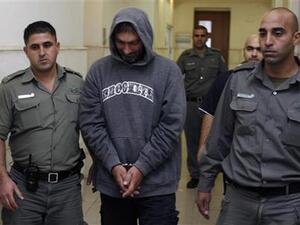 الكسندر سفيتكوفيتش في طريقه الى محكمة بالقدس بين اثنين من حراسه يوم الأربعاء
