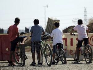 Israeli boys stand with their bicycles as they watch a battery of Iron Dome, a short-range missile defence system, positioned on the outskirts of Tel Aviv on August 30, 2013. (AFP)