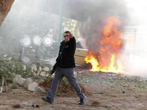 ضابط شرطة اسرائيلي يقف قبالة سيارة تحترق بعد سقوط صاروخ أطلقها نشطاء فلسطينيون من غزة على جنوب اسرائيل
