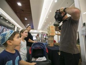 رجل يبين لبعض الاطفال كيف يستخدمون اقنعة الغاز بالقرب من القدس

