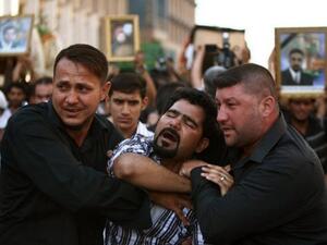 عراقي ينتحب اثناء جنازة زوار شيعة قتلوا اثناء توجههم من كربلاء الى سوريا