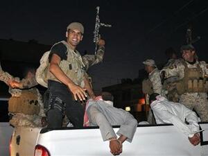 أفراد من قوات الأمن العراقية يحتفلون باعتقال بعض المتمردين في كربلاء