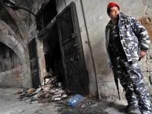 A Lebanese soldier guards the torched library Saturday (Ibrahim Chalhoub/AFP)