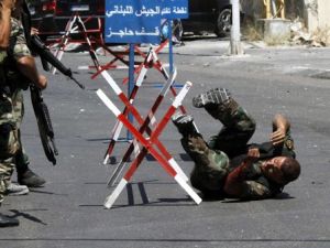 جنود لبنانيون يهرعون لنجدة زميل لهم اصيب خلال الاشتباكات في صيدا الاحد