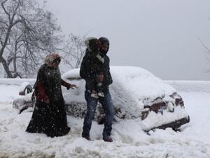 عائلة تسير وسط الثلوج في قرية صوفر شرق لبنان