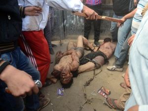 اهالي القرية يقفون قرب جثتي الرجلين