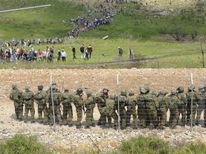 جنود اسرائيليون يقفون حراسة فيما يقترب محتجون سوريون منهم على الحدود بين سوريا واسرائيل بالقرب من مجدل الشمس 
