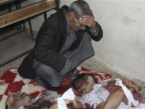 رجل يبكي فوق جثث اشخاص قتلوا بواسطة مسلحين موالين للرئيس السوري بشار الاسد