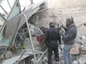 مقاتلون تابعون للجيش السوري الحر يبحثون عن جثث تحت الانقاض بعد غارة جوية على داريا بالقرب من دمشق
