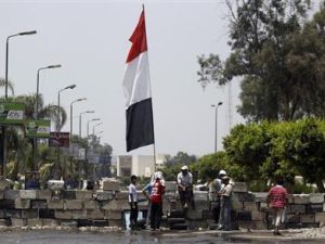 مجموعة من جماعة الاخوان المسلمين ومؤيدو المصري المعزول محمد مرسي يجلسون عند حاجز بميدان رابعة العدوية في القاهرة
