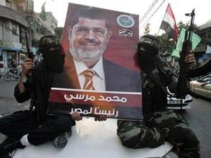 مسلحون من حماس يرفعون صورة للرئيس المصري المنتخب محمد مرسي 
