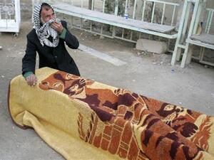 عراقي ينتحب أمام نعش أحد ضحايا تفجيرات بغداد يوم الخميس أثناء جنازته في النجف
