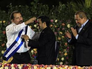 دانييل أورتيجا رئيس نيكاراجوا (الى اليسار) يتلقى التهاني من الرئيس الايراني (في الوسط) فيما يصفق رئيس فنزويلا خلال مراسم التنصيب يوم الثلاثاء
