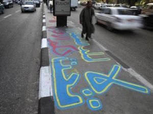 رجل يمر على رصيف مكتوب عليه لا للدستور في القاهرة
