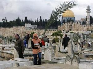 صورة أرشيفية لفلسطينيين يزورون قبور أقارب لهم في مقبرة بالقدس القديمة
