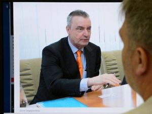 رجل ينظر الى شاشة حاسوب تعرض صورة للديبلوماسي الهولندي في موسكو اونو الديرينبوش
