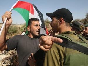 جندي اسرائيلي يوقف متظاهرين اسرائيليين واجانب وفلسطينيين قرب قرية بيت عمر في الضفة
