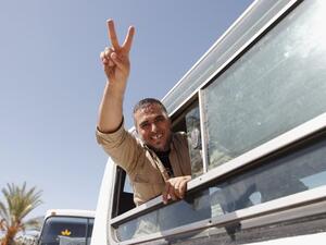 اسير محرر يشير بعلامة النصر من داخل احدى الحافلات التي اقلت الاسرى من اسرائيل