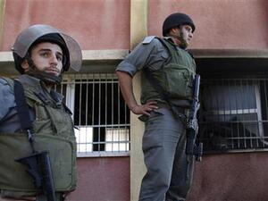 شرطيون اسرائيليون يقفون بجوار نافذة مكسورة لمسجد