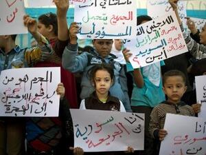 اطفال فلسطينيون فروا مع اسرهم من سوريا يتظاهرون امام مكاتب الانروا في غزة
