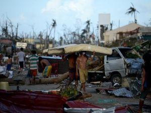 اشخاص يحملون الفرش من فندق في جزيرة لييتي في الفيليبين بعد مرور الاعصار