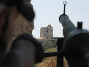 مقاتل من الجيش الحر يصوب سلاحه باتجاه مستشفى الكندي الذي تسيطر عليه قوات النظام في حلب
