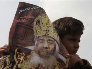 طفل يحمل صورة للبابا شنودة الثالث خارج كاتدرائية العباسية اثناء تشييع جنازته
