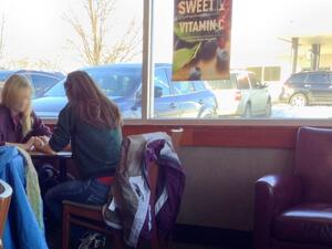 Two friends pray for each other in a Panera Bread in America. (image from Jaraad)