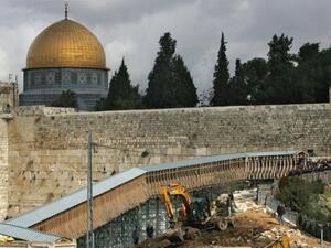 قبة الصخرة تبدو خلف حائط المبكى فيما تقوم جرافة بازالة ممر يؤدي الى باب المغاربة احد مداخل المسجد الاقصى 
