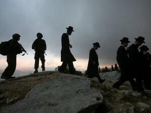 يهود متشددون يتوجهون للصلاة وسط حراسة من الجيش الاسرائيلي في الضفة الغربية  
