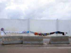 مشردون يعلقون ملابسهم لتجف في مخيم باب السلام بالقرب من حلب/أ.ف.ب