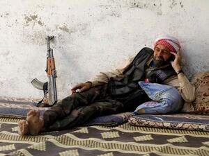 احد مقاتلي الجيش الحر ياخذ استراحة قرب مطار النيرب في حلب