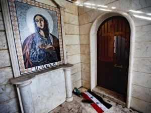 العلم السوري ملقى امام كنيسة سانتا انا في ادلب التي كان الجيش السوري قد حولها الى ثكنة عسكرية