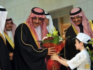 طفل سوري يقدم ورودا الى وزير الداخلية السعودي محمد بن نايف خلال افتتاح حملة التبرع للاطفال السعوديين في الرياض
