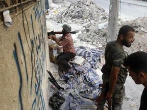 مقاتل من الجيش السوري الحر يحمل قذيفة صاروخية في احد شوارع حلب
