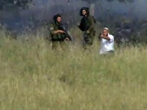 صورة من شريط فيديو تم تحميله على يوتيوب تظهر مستوطنا يطلق النار من مسدس على قرويين فلسطينيين يرمون الحجارة 
