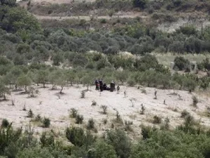 اشخاص ينتظرون العبور الى تركيا في منطقة قروية على الجانب السوري من الحدود بين سوريا وتركيا 
