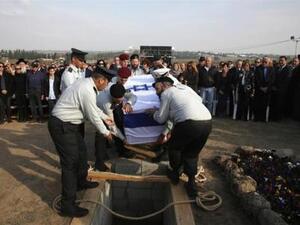 عسكريون اسرائيليون ينزلون جثمان شارون قبره في مزرعة أسرته بجنوب اسرائيل
