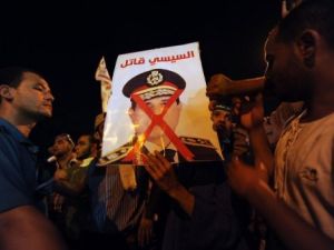 ارشيف/ انصار الرئيس المصري المعزول محمد مرسي يحملون صوررة تصف قائد الجيش عبدالفتاح السيسي قاتلا