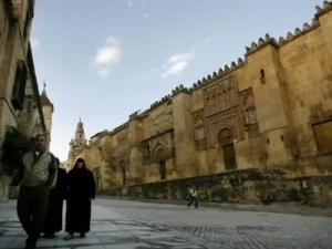 مسلمون يسيرون بجانب حائط مسجد قرطبة في اسبانيا
