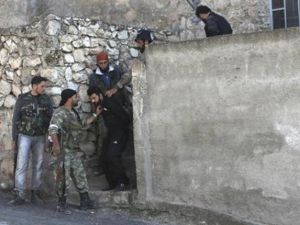 افراد من الجيش السوري الحر يعتقلوان رجلا يشتبه في انه من القوات المؤيدة للحكومة في احد المدن التابعة لادلب
