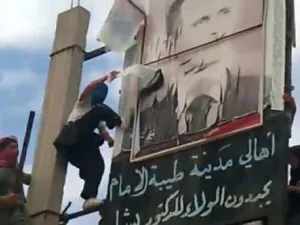 صورة من موقع يوتيوب تظهر متظاهرين يمزقون صورة للرئيس بشار الاسد 
