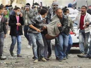 محتجون مصريون يحملون زميلا لهم أصيب في الاشتباكات بميدان التحرير
