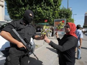 تونسية تقدم ورودا لشرطي في جادة الحبيب بورقيبة خلال تظاهرة لناشطين في المعارضة
