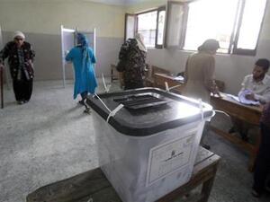 نساء خلف صندوق انتخاب في مركز اقتراع بالقاهرة
