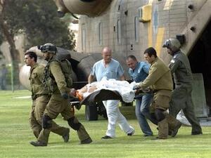 جنود ومسعفون اسرائيليون ينقلون جنديا اصيب في الهجوم لدى وصولهم الى مستشفى بجنوب اسرائيل
