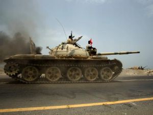 جنود يمنيون ورجال قبائل موالون للجيش على متن دبابة للجيش في مدينة زنجبار
