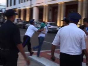 لقطة من الفيديو تظهر دفع رجل شرطة لفتاة مشاركة في الاحتجاج بقوة بالغة كادت تطيحها ارضا