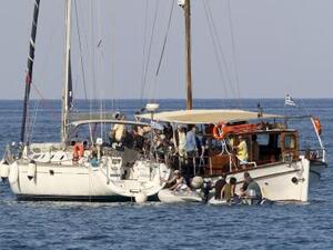 نشطاء مؤيدون للفلسطينيين يعتلون قارب صيد ضمن القافلة قرب جزيرة كريت اليونانية يوم 26 يونيو حزيران 2015
